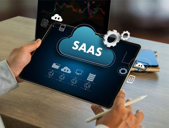 Person holding a tablet showing a SaaS cloud platform